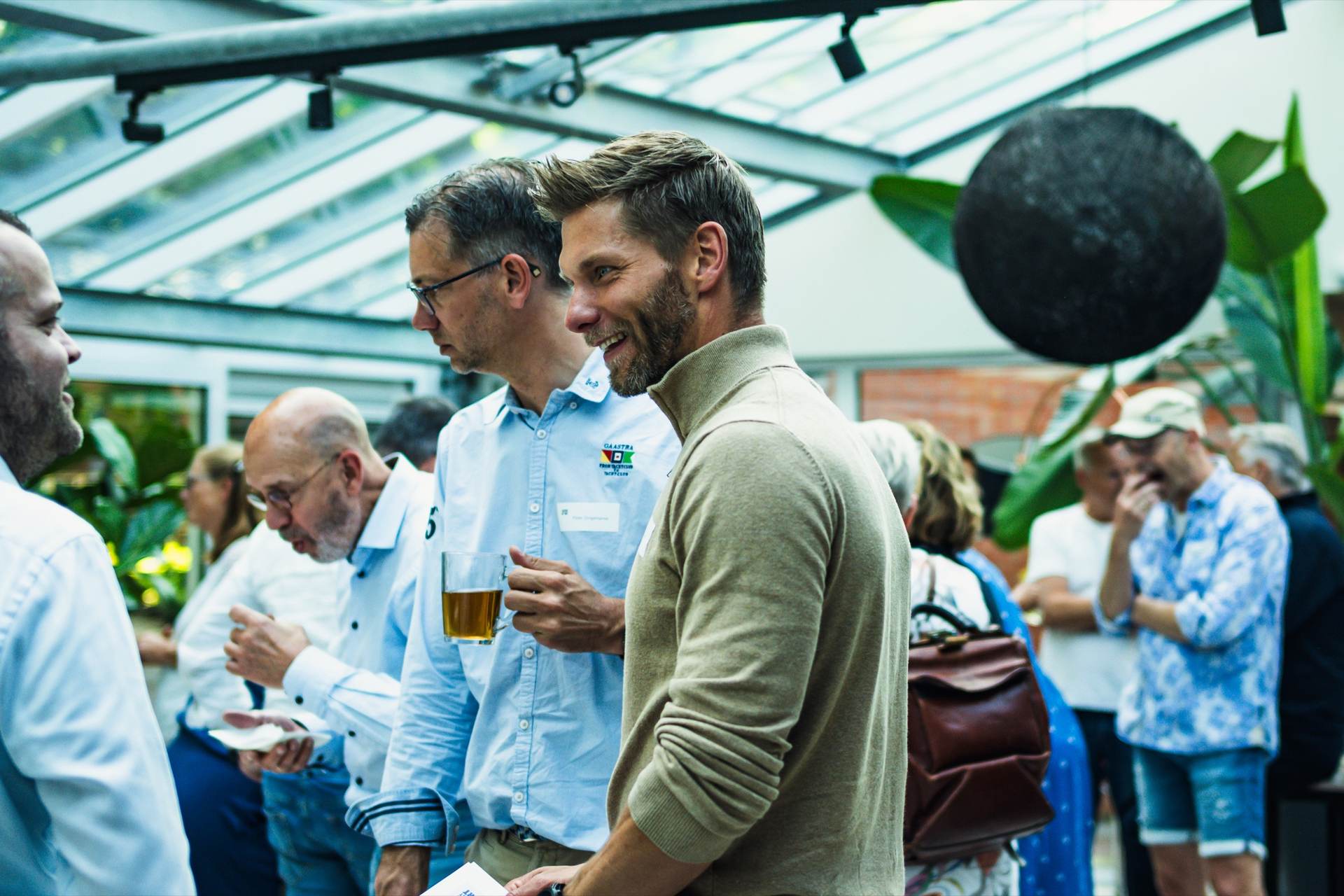 Lachende deelnemers in gesprek tijdens een bijeenkomst van Agenda voor het Hart